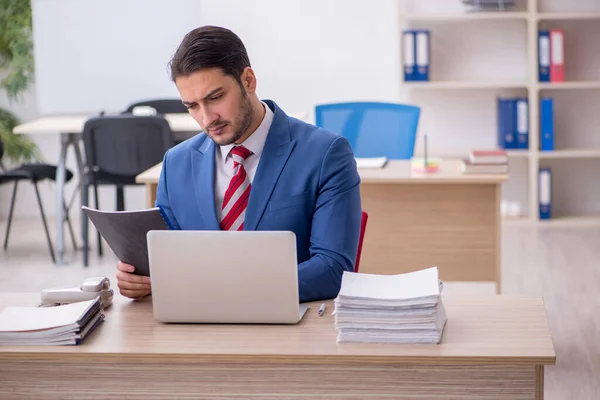 Jovem empregado atraente que trabalha no escritório — Fotografia de Stock