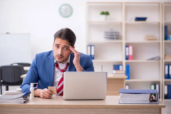 Ung manlig anställd som lider på arbetsplatsen — Stockfoto