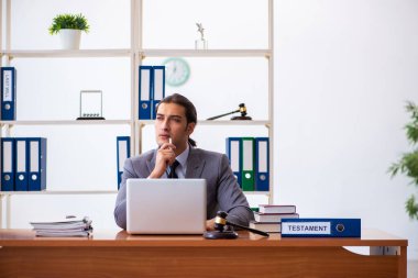 Genç erkek avukat ofiste oturuyor.