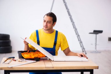 Genç erkek marangoz içeride çalışıyor.