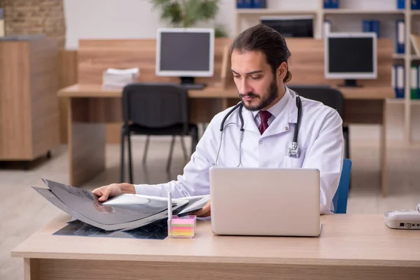 Genç erkek doktor radyoloji uzmanı ofiste oturuyor. — Stok fotoğraf