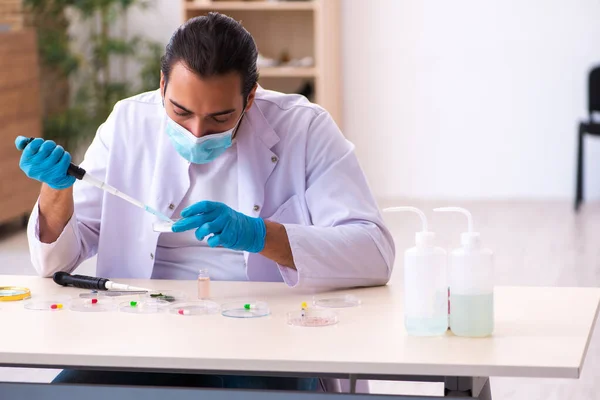 Joven químico masculino trabajando en el laboratorio durante una pandemia —  Fotos de Stock