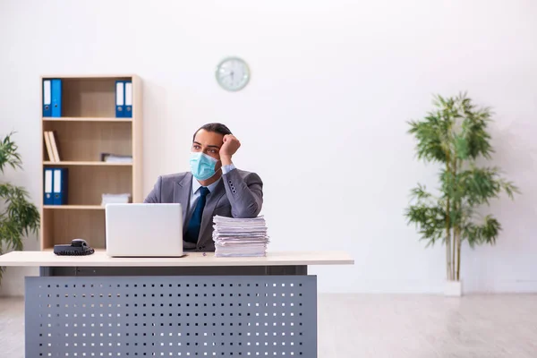 Young male employee wearing mask during pandemic — Stock Photo, Image