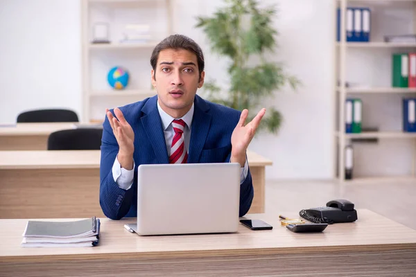 Junge männliche Angestellte sitzen im Büro — Stockfoto