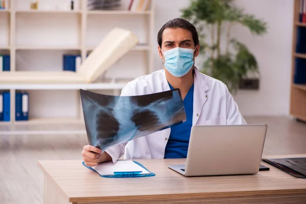 Jonge mannelijke arts radioloog draagt gezichtsmasker tijdens pandemie — Stockfoto