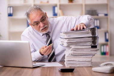 Ofisteki aşırı işten memnun olmayan yaşlı bir erkek işçi.