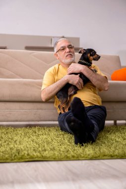 Evde köpeği olan yaşlı bir adam.