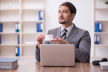 Molada kahve içen genç bir erkek.