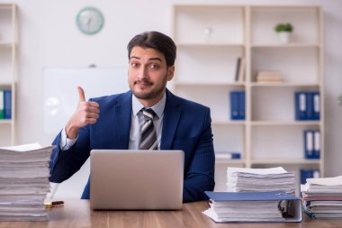 Ofisteki aşırı işten memnun olmayan genç bir erkek işçi.