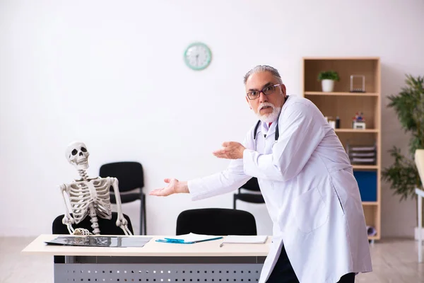 Γέρος άνδρας γιατρός και σκελετός ασθενής στην κλινική — Φωτογραφία Αρχείου