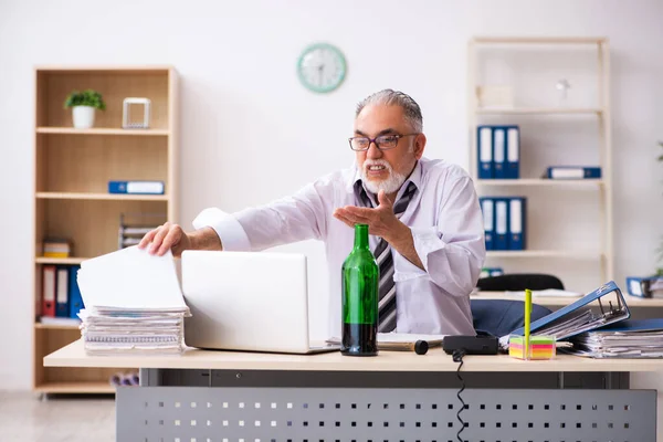 Un vieil employé boit de l'alcool au bureau — Photo