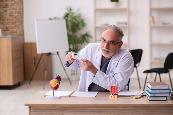 Vecchio dentista maschio insegnante seduto in classe — Foto Stock