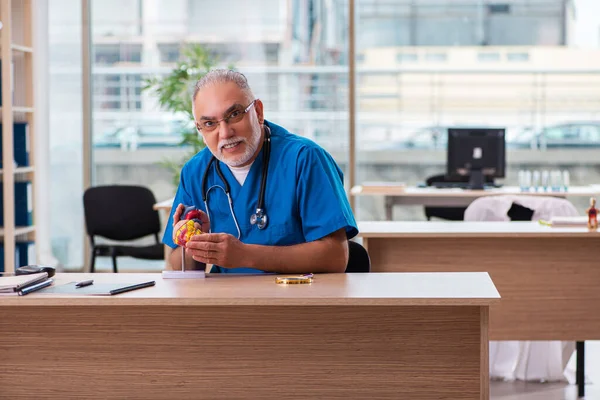 Klinikte çalışan yaşlı bir erkek kardiyolog. — Stok fotoğraf