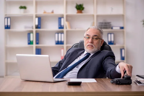 Old male employee working in the office — Stock Photo, Image