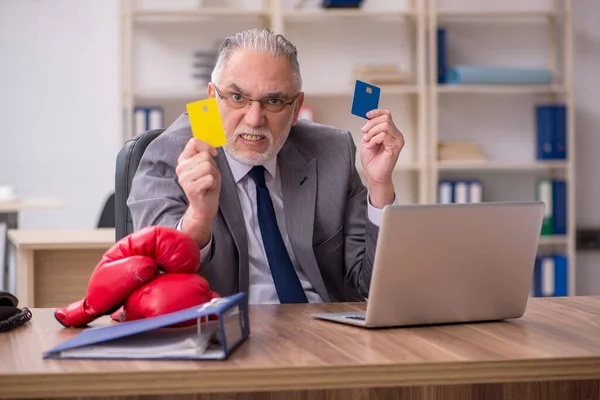 Velho empresário empregado segurando cartão de crédito e vestindo boxe — Fotografia de Stock