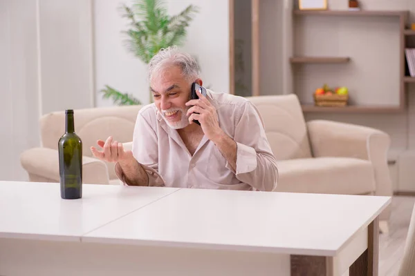 Vieil homme buvant de l'alcool à la maison — Photo