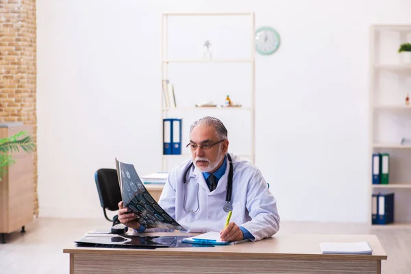 Stary lekarz radiolog pracujący w szpitalu — Zdjęcie stockowe
