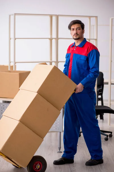 Jovem empreiteiro masculino em conceito de movimento no local de trabalho — Fotografia de Stock