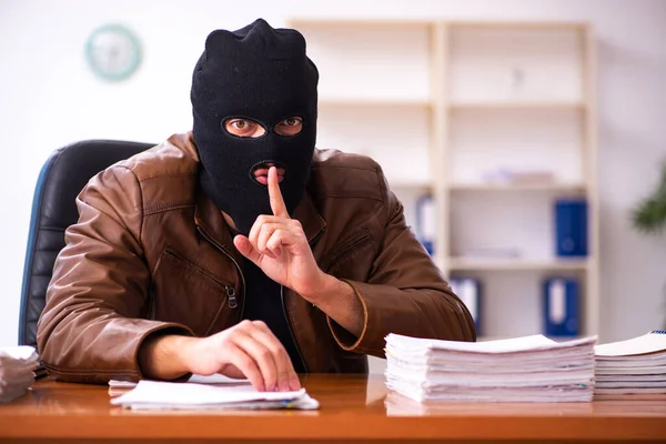 Ung man i Balaclava stjäl information från kontoret — Stockfoto