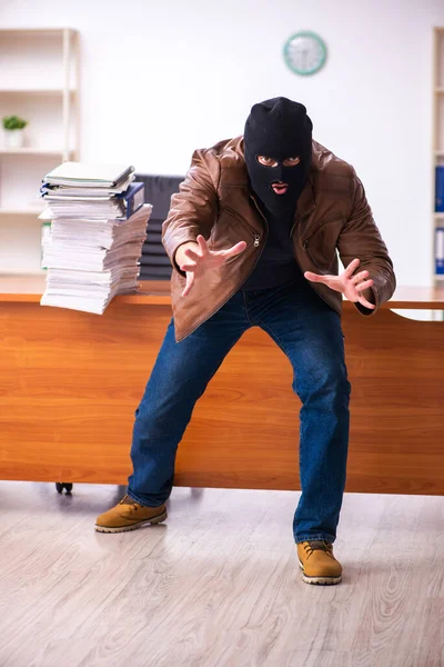 Young man in balaclava stealing information from the office — Stock Photo, Image