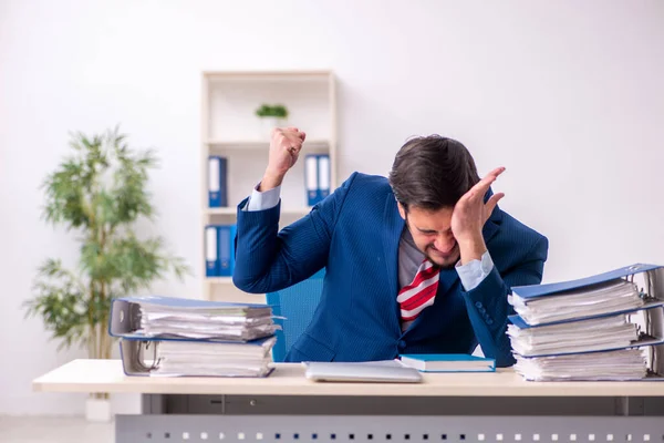Jeune employé masculin mécontent du travail excessif au bureau — Photo