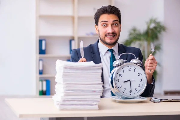 Jovem empresário empregado comer despertador-relógio — Fotografia de Stock