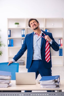 Ofisteki aşırı işten memnun olmayan genç bir erkek işçi.