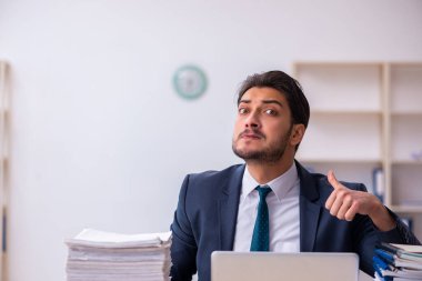 Genç işadamı ve ofiste çok fazla iş var.