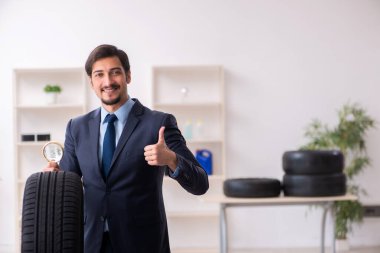 Genç adam ofiste lastikleri inceliyor.