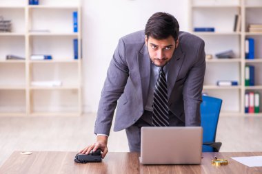 Genç yakışıklı işadamı ofiste çalışıyor.