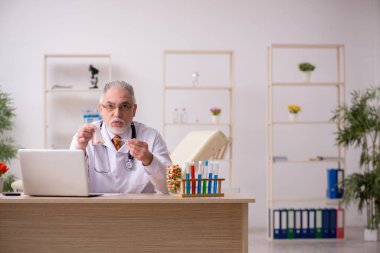 Klinikte çalışan yaşlı bir doktor.