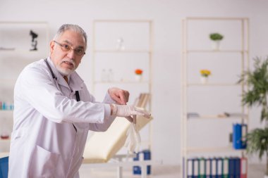 Klinikte çalışan yaşlı bir doktor.