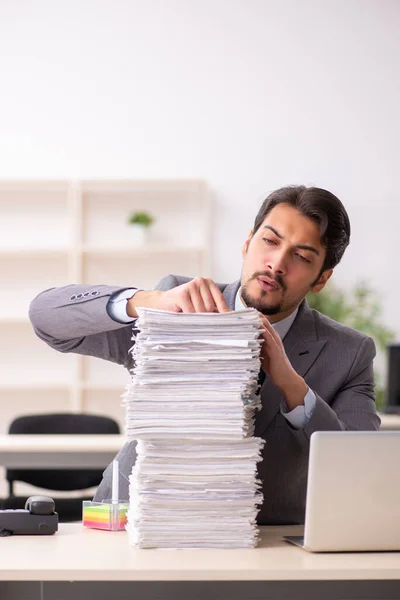 Joven empleado masculino descontento con el trabajo excesivo en la oficina — Foto de Stock