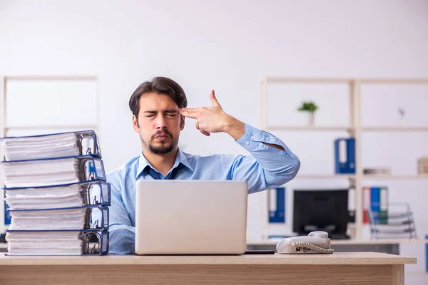 Joven empleado masculino y demasiado trabajo en la oficina —  Fotos de Stock