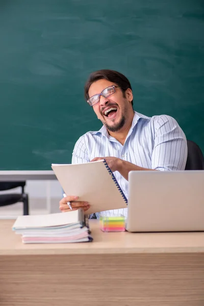 Jeune professeur masculin devant le tableau noir — Photo