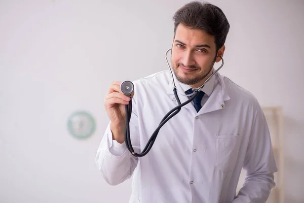 Jeune homme médecin tenant un phonendoscope à la clinique — Photo