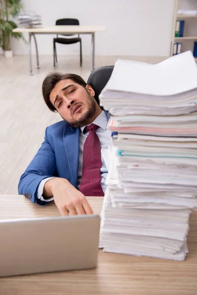 Mladý muž zaměstnanec a příliš mnoho práce v kanceláři — Stock fotografie