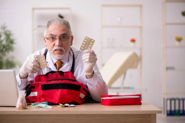 Old male doctor in first aid concept — Stock Photo, Image