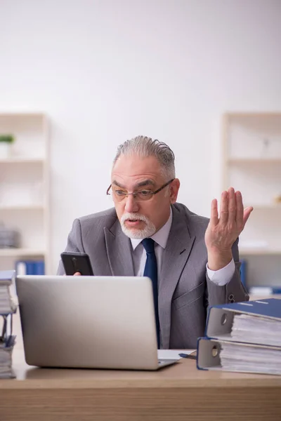 Vecchio dipendente maschio infelice con il lavoro eccessivo in ufficio — Foto Stock