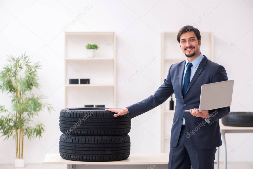 Young man selling tires in the office