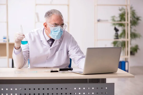 Oude mannelijke chemicus werkt in het lab tijdens een pandemie — Stockfoto