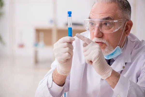 Oude mannelijke chemicus werkt in het lab tijdens een pandemie — Stockfoto