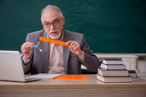 Alter männlicher Lehrer Chemiker vor der Tafel — Stockfoto