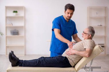 Yaşlı erkek hasta, genç doktor.