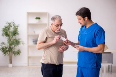 Yaşlı erkek hasta, genç doktor.