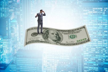 İş adamı 100 dolarlık banknotla uçuyor.