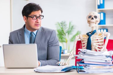 İskeletle çalışan bir iş adamı.