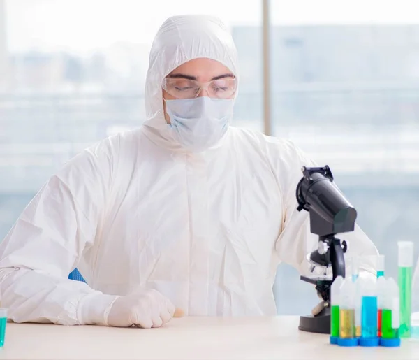 Jovem estudante de química que trabalha em laboratório em produtos químicos — Fotografia de Stock