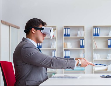 Ofiste sanal gerçeklik gözlüklü bir iş adamı var.