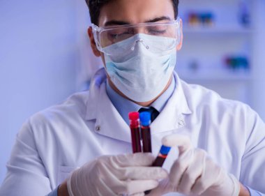 Laboratuvar asistanı hastanede kan örneklerini test ediyor.